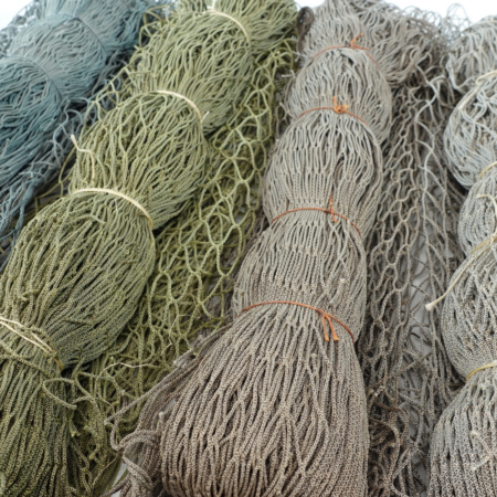 Heavy-duty dyed fishing net base for custom camouflage garment fabrication and gear concealment.